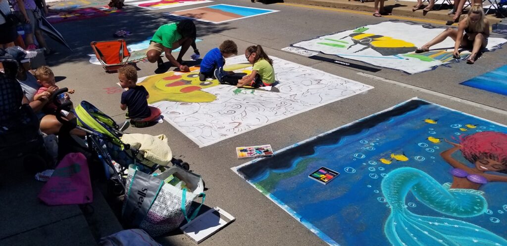 Kids coloring in a chalk walk square