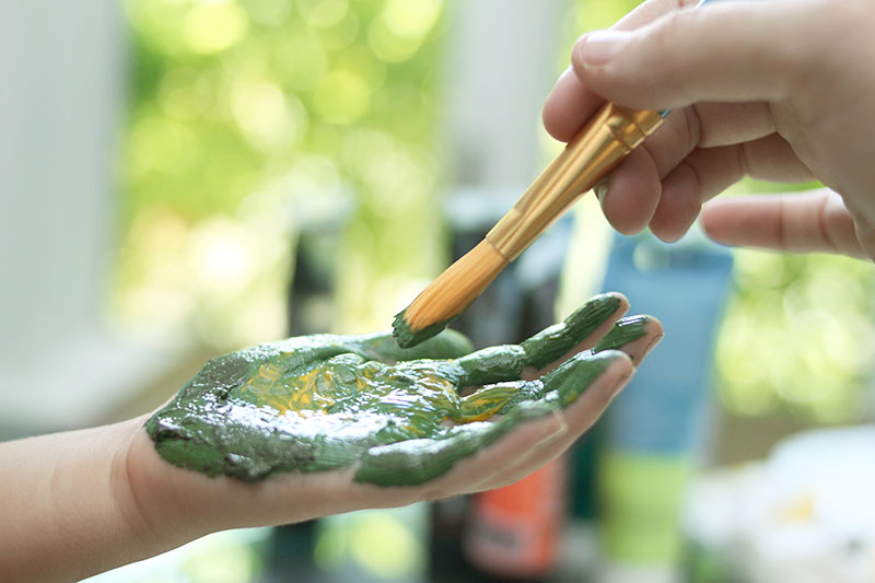 Painting little hands for a dino handprint project