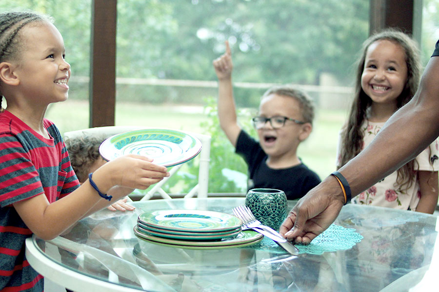 Kid telling joke during family meal time